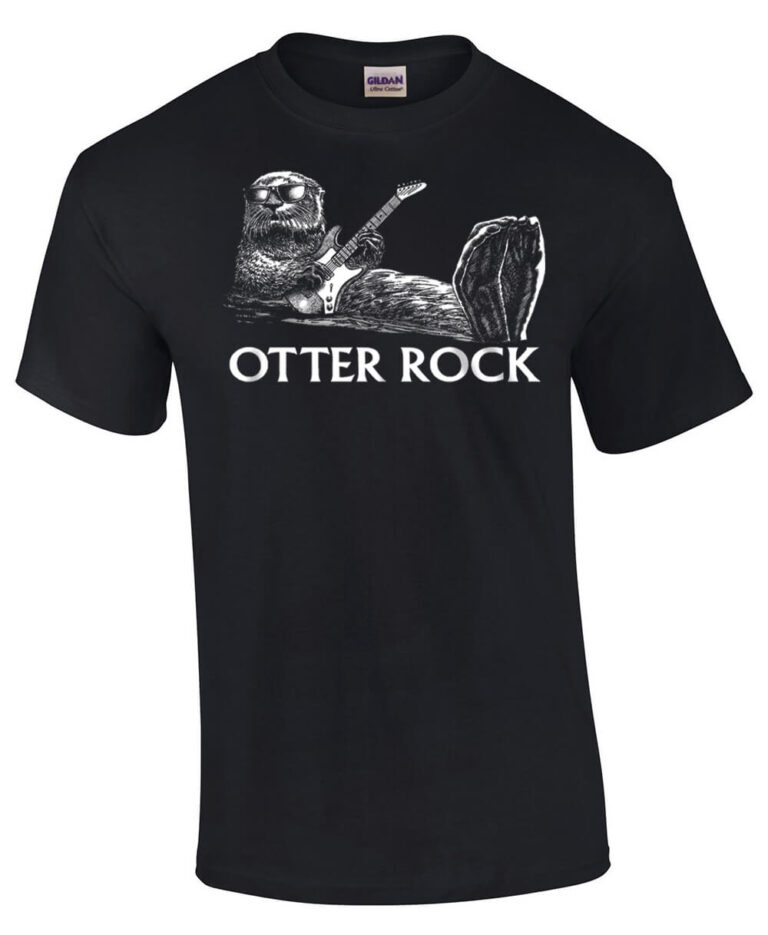 Black t-shirt with otter wearing sunglasses, floating on his back playing guitar. Caption: Otter Rock